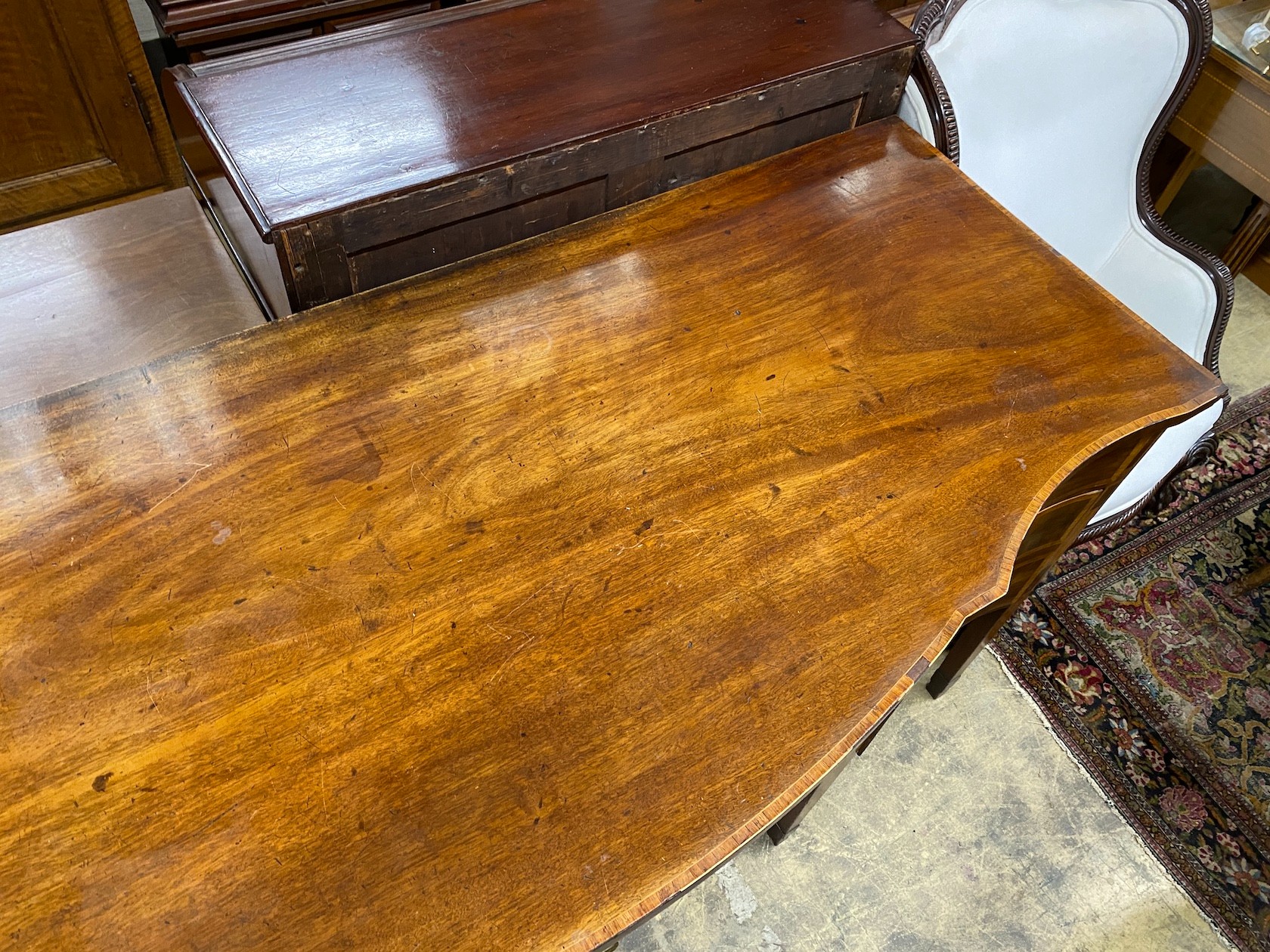 A George III satinwood banded mahogany serpentine sideboard with central tambour compartment width 199cm, depth 80cm height 95cm